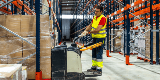 Worker applying MHE training to warehouse handling work
