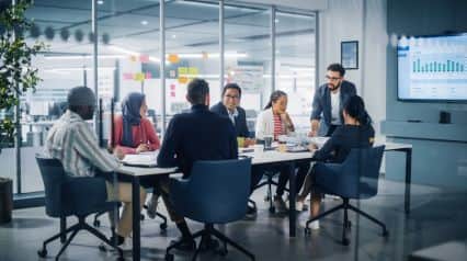 workers in a meeting room assessing organizational management practices