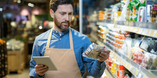 Man holding grocery product conducting price inspection for compliance