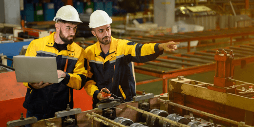 Warehouse workers in PPE looking at equipment