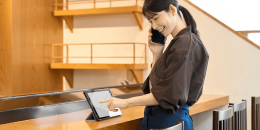 Woman working in hospitality checking work tablet