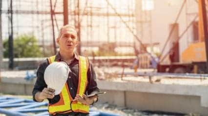 trabajador de la construcción bebiendo agua debido al calor bajo el sol
