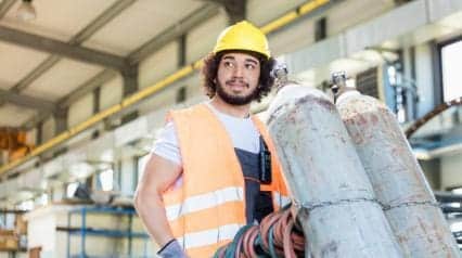 worker carries gas cylinder safely
