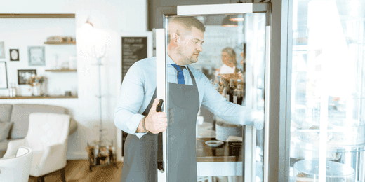 Staff checking fridge before filling out a cold food holding safety checklist