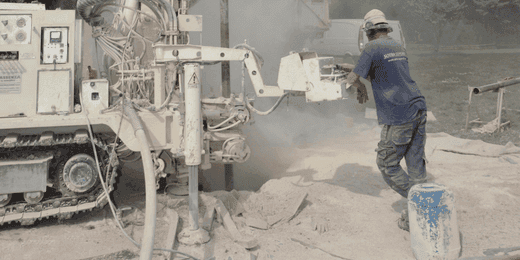 Excavation worker performing core drilling operations