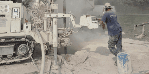 Excavation worker performing core drilling operations