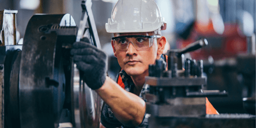 Man in PPE working with manufacturing equipment
