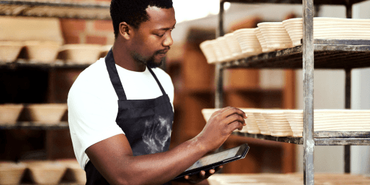 A baker using his tablet to monitor his baking equipment.