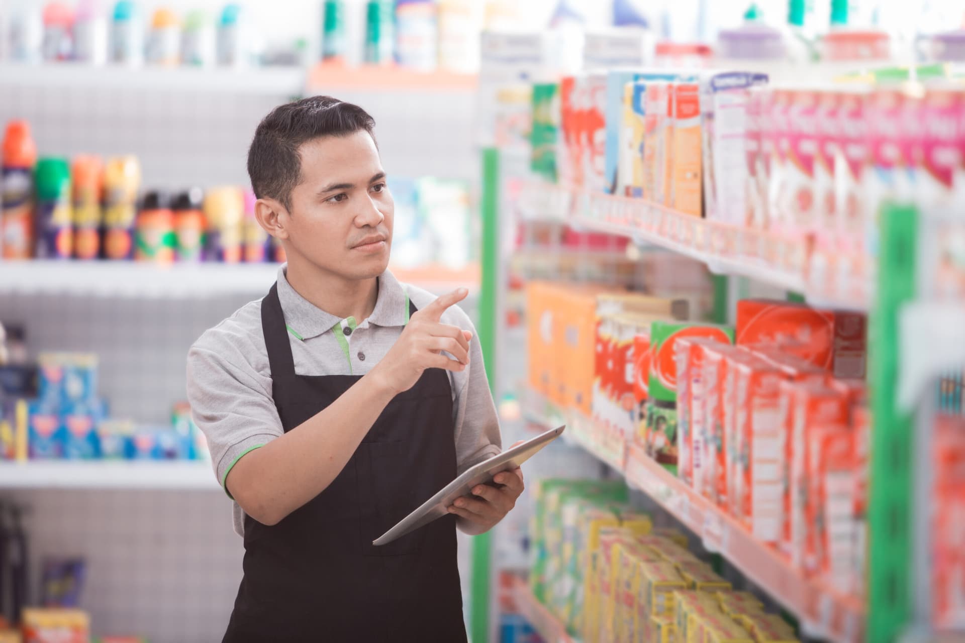 A grocery worker performing checks using grocery management software