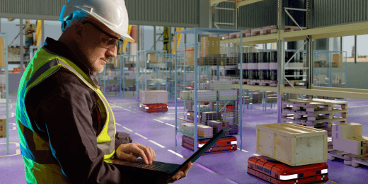 Worker in a warehouse holding a laptop