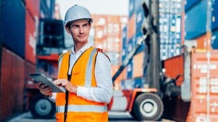 a supply chain risk management professional checking deliveries and inventory using a tablet