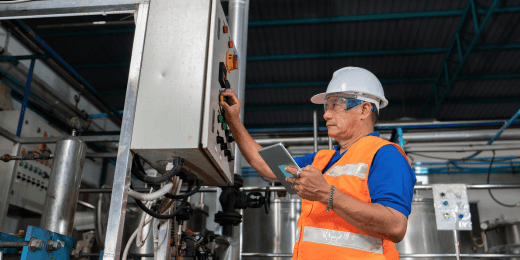 A safety officer operating an industrial control panel during a plant inspection.